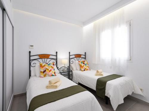 Dos camas en una habitación con paredes blancas. en Apartment in Playa de Mogán with Sea Views, en Mogán
