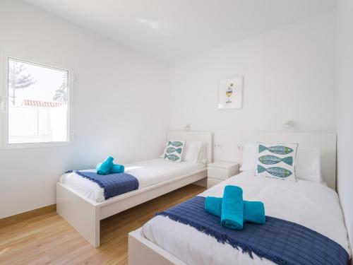Una habitación blanca con dos camas y un sofá. en Bungalow in Maspalomas near Golf & Beach, en San Bartolomé