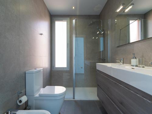 a bathroom with a toilet and a sink and a mirror at Chalet in Maspalomas with Heated Pool in San Bartolomé de Tirajana