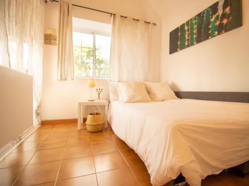 a bedroom with a white bed and a window at Bungalow in Maspalomas near Golf & Beach in San Bartolomé de Tirajana