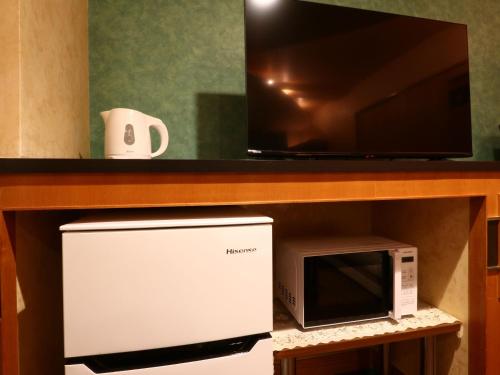 a microwave and a microwave oven under a counter at ホテル森のしずく in Shimoda