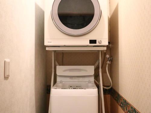a microwave sitting on top of a washer and dryer at ホテル森のしずく in Shimoda