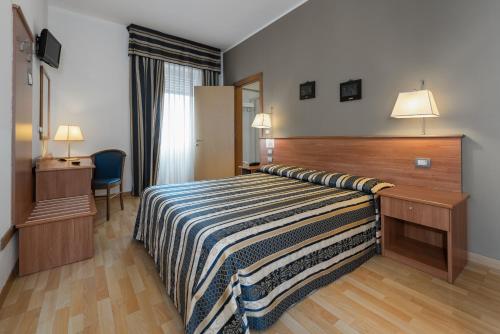 a hotel room with a bed and a desk at Hotel Piccolo in Verona