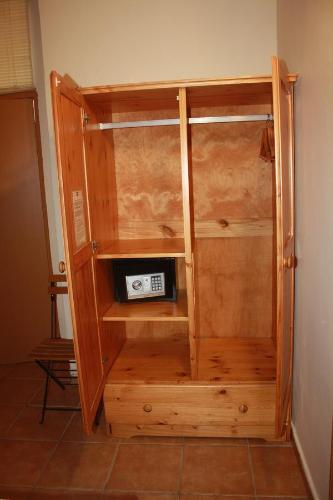 a wooden cabinet with a microwave inside of it at Governor's Inn Apartments in Gibraltar