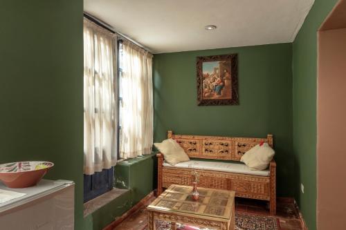 a green room with a couch and a table at Tambo del Arriero Hotel Boutique in Cusco