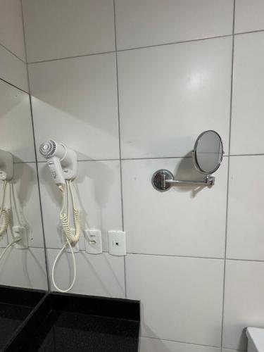 a shower stall with a phone and a mirror at RM Beach Paradise - Barra Iloa Residense in Barra de São Miguel