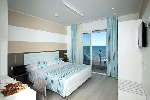 a bedroom with a bed and a view of the ocean at Lungomare Relax Residence in Misano Adriatico