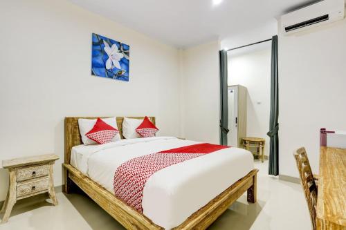 a bedroom with a bed with red and white pillows at Hotel O March 67 Stay in Balian