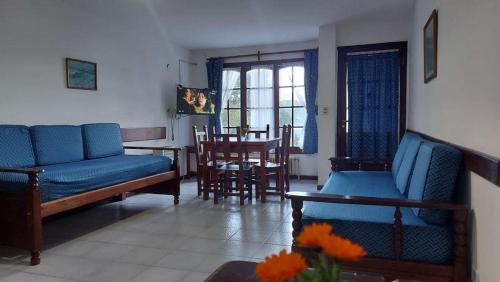 a living room with blue couches and a table and chairs at CASA del LAGO Bariloche in San Carlos de Bariloche