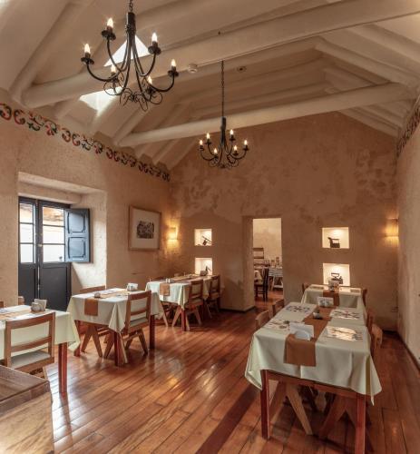 a dining room with tables and chairs and a chandelier at Tambo del Arriero Hotel Boutique in Cusco