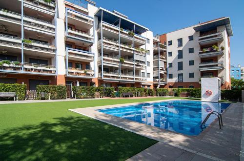 un complesso di appartamenti con piscina di fronte a un edificio di Cambrils Blau Residencial Team019 España a Cambrils
