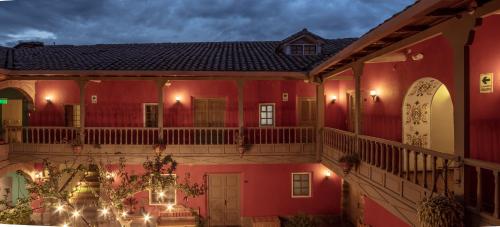 a red building with a balcony at night at Tambo del Arriero Hotel Boutique in Cusco