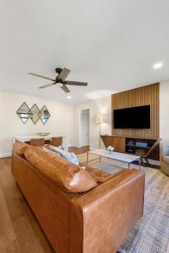 a living room with a brown couch and a flat screen tv at Stylish 1-Bedroom Condo Downtown Atlanta in Atlanta