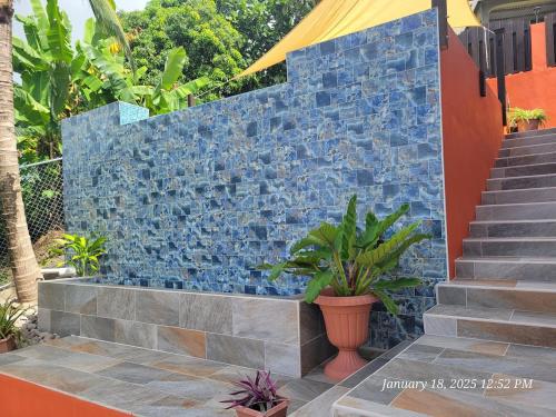 a blue stone wall with stairs and plants at Southern Sunset Villa in Choiseul