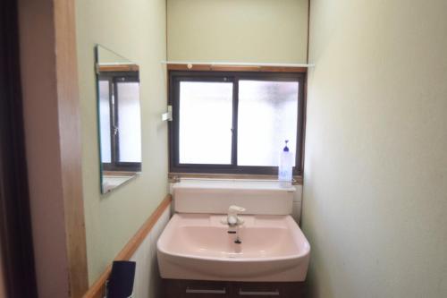 a bathroom with a sink and a mirror and a window at Asoviva in Anan