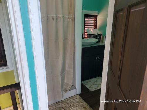 a bathroom with a shower curtain and a sink at Southern Sunset Villa in Choiseul