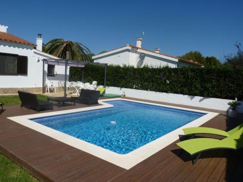 una piscina con sillas y una casa en Belvilla by OYO Bon Relax II45 en Sant Pere Pescador