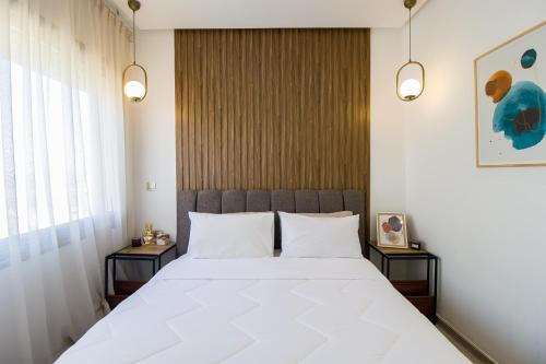 a bedroom with a large white bed with two side tables at Luxury Marina Retreat, Walk to the Beach in Tangier