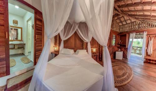 a bedroom with a bed with a canopy at Barrinha dos Ventos Barrinha de Baixo Ceara Quartos Casas Kitesurf in Acaraú