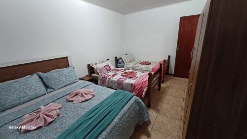 カンポス・ド・ジョルドンにあるApartamento Kit 01, em Campos do Jordãoのベッドルーム1室(弓の付いたベッド2台付)
