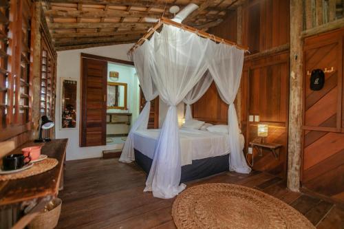 a bedroom with a bed with a mosquito net at Barrinha dos Ventos Barrinha de Baixo Ceara Quartos Casas Kitesurf in Acaraú