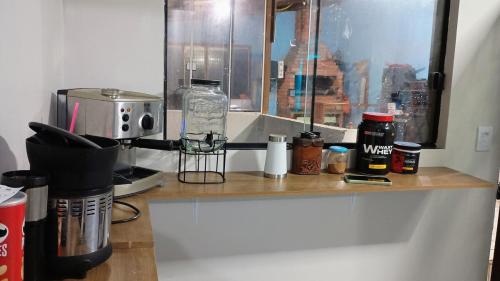 een aanrecht met een koffiezetapparaat en een raam bij Morada do Altíssimo in Uruguaiana