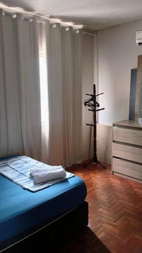 a bedroom with a bed and a cross in the corner at Morada do Altíssimo in Uruguaiana