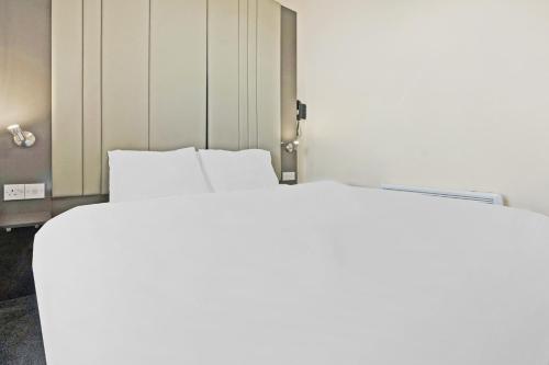 Ένα ή περισσότερα κρεβάτια σε δωμάτιο στο OYO The Baltimore Hotel