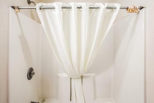 a white shower curtain in a bathroom at OYO Hotel Yuma AZ - I-8 US-95 in Yuma