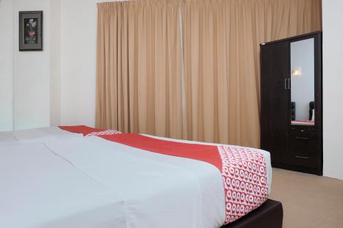 a bedroom with a white bed and a window at OYO 90180 Gemilang Hotel Kerteh in Dungun