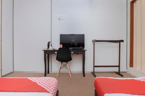 a desk with a computer and a chair in a room at OYO 90180 Gemilang Hotel Kerteh in Dungun