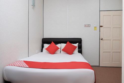 a bed with red pillows in a room at OYO 90180 Gemilang Hotel Kerteh in Dungun