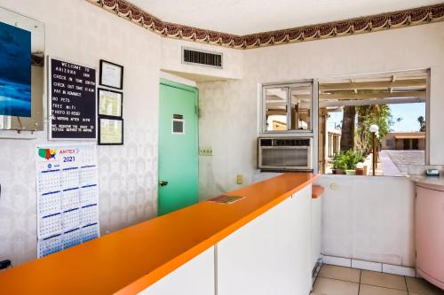 a kitchen with an orange counter and a green door at OYO Hotel Yuma AZ - I-8 US-95 in Yuma