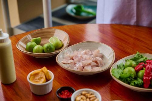 a wooden table topped with bowls of food and vegetables at Casa Andina Standard Chincha in Chincha Alta