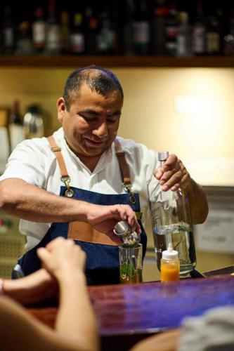 a man in an apron standing at a table at Casa Andina Standard Chincha in Chincha Alta