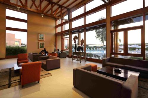 a large living room with couches and tables and windows at Casa Andina Standard Chincha in Chincha Alta