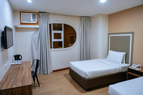 a small hotel room with a bed and a desk at S Hotel & Residences in Cebu City