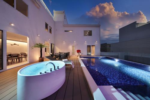 a bath tub sitting on a deck next to a swimming pool at クリスタルヴィラ白浜パークサイド in Shirahama