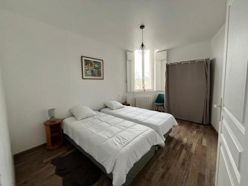a bedroom with a large bed with white sheets at Appartement lumineux 2 ch, proche plage & commerces - FR-1-706-31 in Châtelaillon-Plage