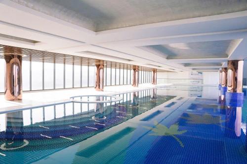 ein großes Hallenbad mit blauem Wasser in der Unterkunft Wyndham Lynn Times Thanh Thủy in La Phu