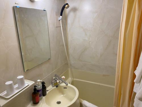 a bathroom with a sink and a toilet and a shower at Hotel Crown Hills Kumamoto in Kumamoto