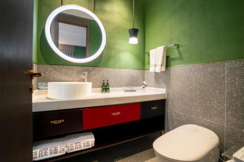 a bathroom with a sink and a mirror and a toilet at THE YARD HOTEL BEIJING,BianyiFang - steps The Forbidden City - strolling through the imperial gardens is incredibly easy - The guest rooms blend modern comfort with Chinese charm - Peking duck - living in history Your Beijing adventure begins here in Beijing