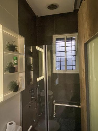 a bathroom with a shower and a toilet and a window at Petite Stylish 1Bed Apt Courtyard Lekki1 in Lekki Phase 1
