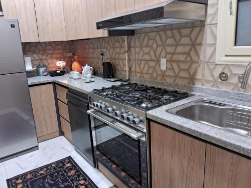 a kitchen with a stove top oven next to a sink at 15 Bustan Down town in Cairo