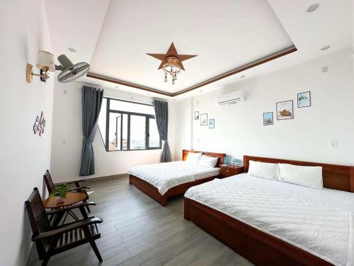 a bedroom with two beds and a star on the ceiling at SÓNG Coffee & Homestay in Quy Nhon