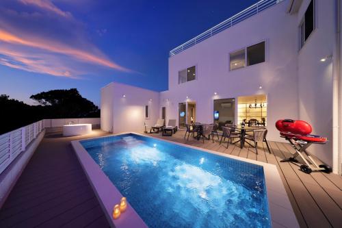 a villa with a swimming pool and a house at クリスタルヴィラ白浜パークサイド in Shirahama