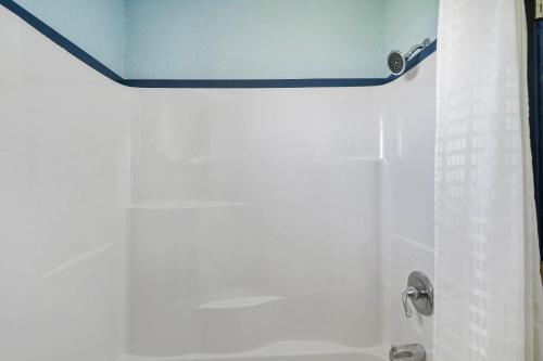 a shower with a blue ceiling in a bathroom at OYO Hotel Luling TX Downtown I-10/US-90 in Luling