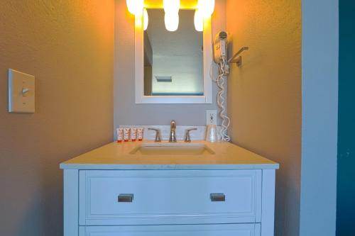 a bathroom with a sink and a mirror at OYO Waves Hotel Newport OR - NYE Beach in Newport
