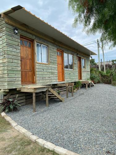 a wooden cabin with benches in front of it at Jacaranda in Neptunia