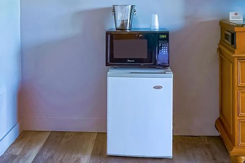 a microwave sitting on top of a refrigerator at OYO Waves Hotel Newport OR - NYE Beach in Newport